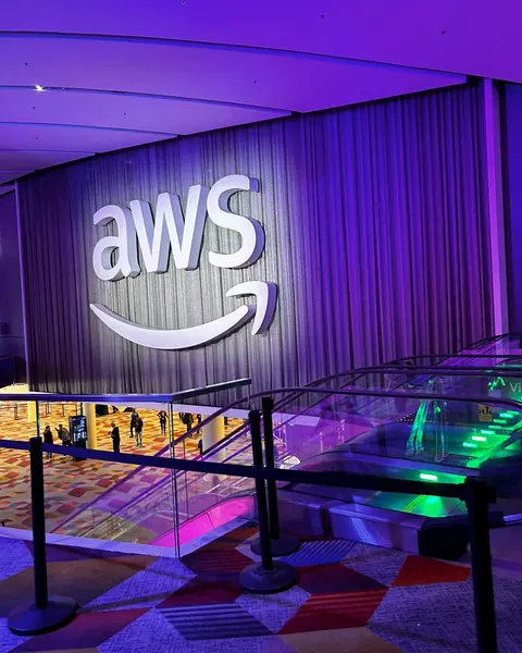 Logo gigante de AWS iluminado en morado en el hall de AWS re:Invent en Las Vegas
