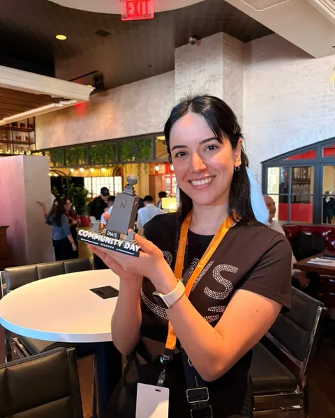 Integrante de AWS User Group Ecuador posa con la réplica del monumento de AWS Community Day Ecuador en Las Vegas